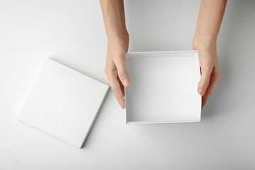 Female hands with open box on white background