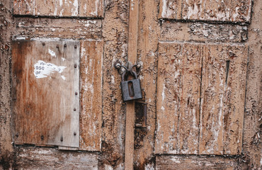 Old weathered grunge rusty locked padlock old wooden board door