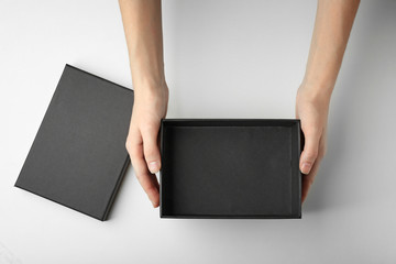 Female hands with black open box on white background