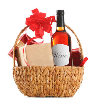 St. Valentines Day concept. Red wine bottle and gift boxes in basket isolated on white