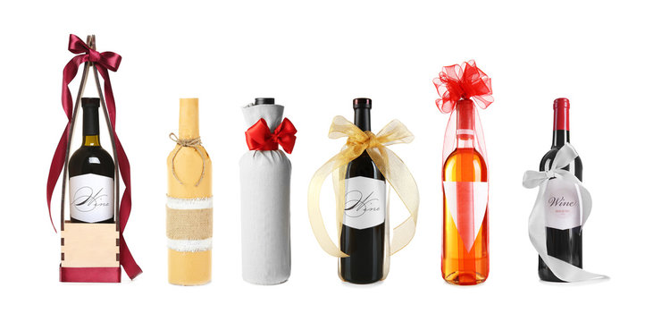 Set of wine bottles with festive decor on white background