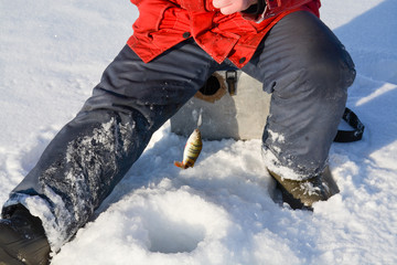 Fototapeta na wymiar man fishing on a frozen lake in the winter in Russia