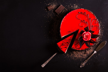 Red cake with rose, chocolate flower, on dark background. Free space for your text. Selective focus