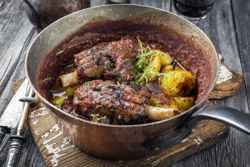 Lamb Knuckles with Fried Potatoes in Burgundy Sauce in Casserole