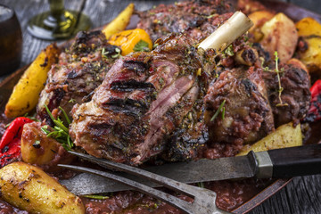 Lamb Knuckles with Fried Potatoes in Burgundy Sauce as close-up on Plate
