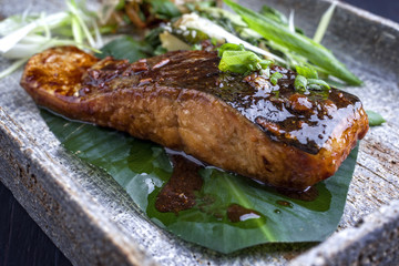 Traditional Japanese Salmon Teriyaki as close-up on Banana Leaf