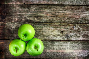 Ripe green apples on wooden background