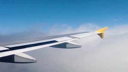 Landing of a aeroplane passing by clouds 