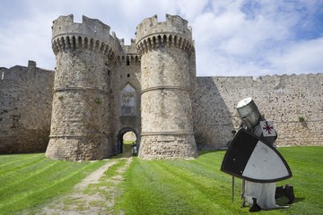 Fototapeta na wymiar Medieval knight with fortifications of the Old Town of Rhodes - Marine Gate (Sea Gate), Greece
