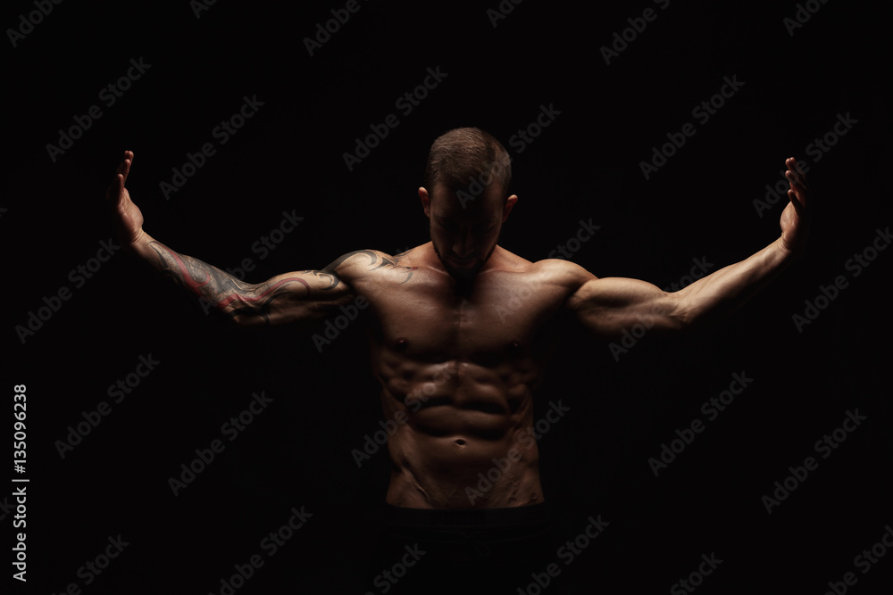 Wall mural Strong athletic man showes naked muscular body