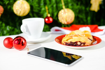 Mobile smartphone, coffee and pastry on light background. Closeup photo flat lay style
