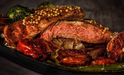 steak rare with the blood, pepper, garlic, tomatoes, broccoli, roasted on the grill, in a frying pan at home