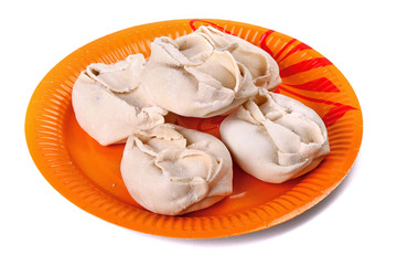 Frozen manti laying on the orange plate