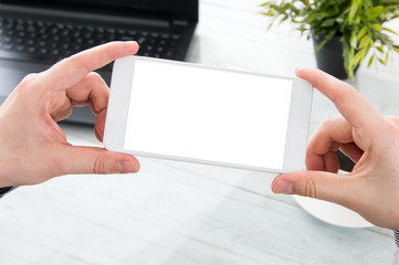 Businessman holds white smartphone with empty screen