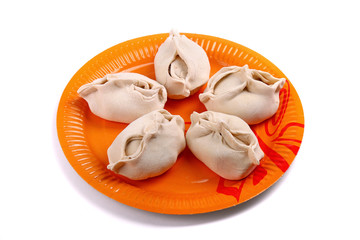 Frozen manti laying on the orange plate