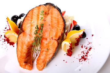 Fried salmon fish with a lemon and olives