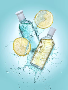 Two bottles of cosmetic moisturizing lotion in the big water splash. Two lemon slices near the bottles. Turquoise gradient background