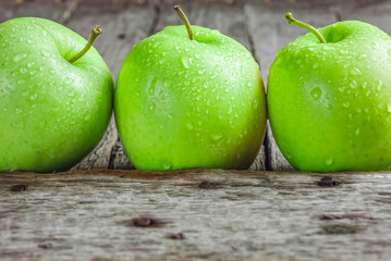Ripe green apples on wooden background