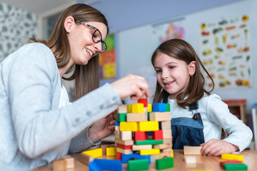 Mother and Daughter Playing Together with colorful building toy blocks