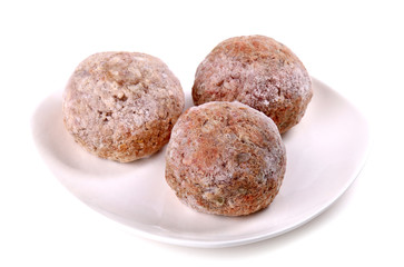 Frozen ground meat on a white plate