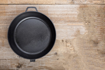 a cast-iron frying pan on a wooden background