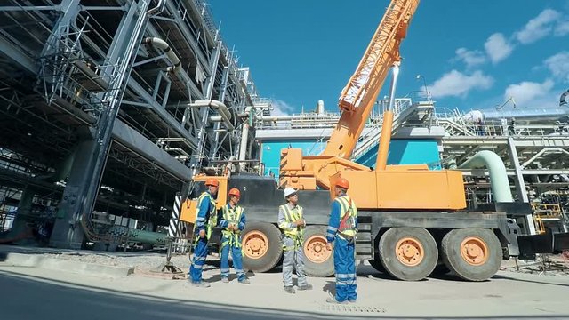 Group of indusrial workers talking at a building site. Industrial scene background