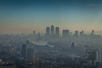 a morning in London with a view of Canary Wharf with smog, air pollution