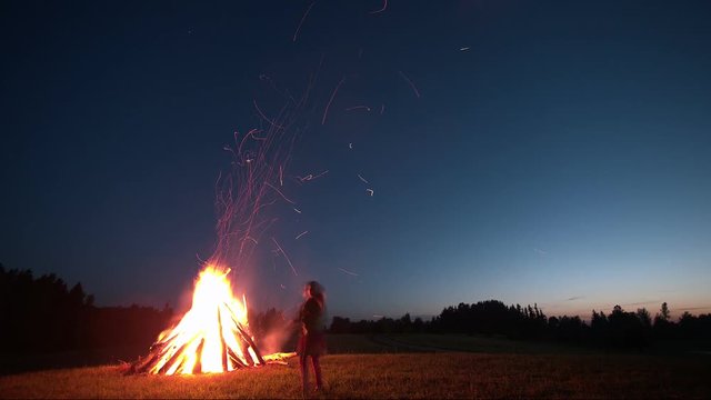 Time-lapse of camp fire on St. John's Day in meadow with sunset