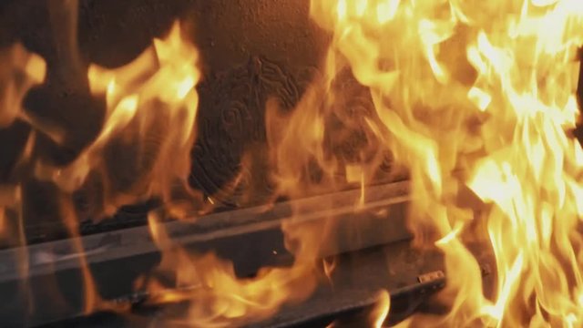 Slowmotion close up of high flames burning piano and tree in forest