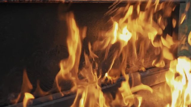 Slowmotion close up of high flames burning piano and tree trunk in forest