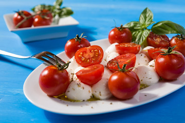Closeup of Italian caprese with mozzarella, cherry tomatoes and