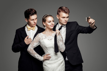 Two handsome men and beautiful bride, studio