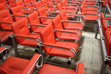 Armchairs with metal frame and red leather upholstery in a row