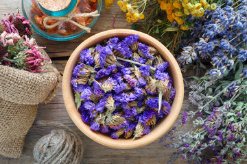 Obraz na płótnie Canvas Medicinal herbs, mortar and bag of dry healthy flowers on wooden board