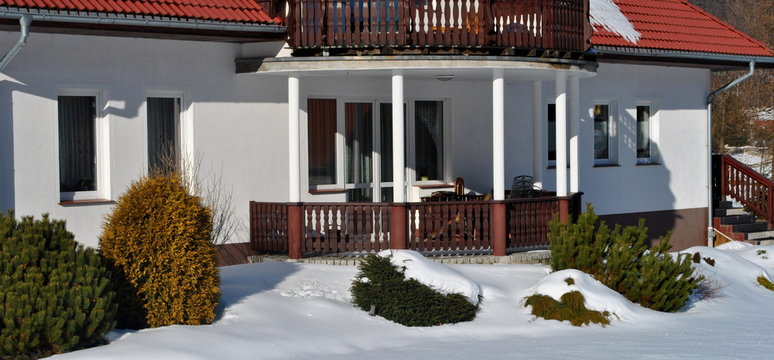 Ogr&oacute;d przy domu pod śniegiem