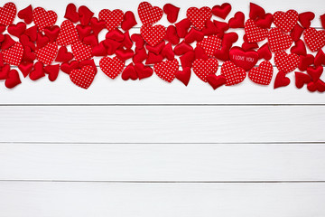 Red hearts border on white wooden background. Valentines Day background. Top view, copy space