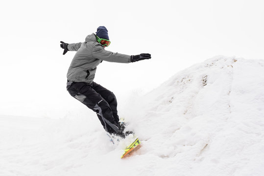 Snowboarder riding on slope in foggy day