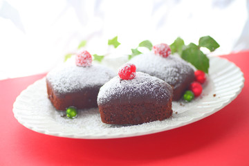 Chocolate cakes with fresh raspberries, tiny ornaments and ivy leaves with room for text