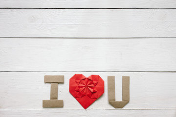 Red origami heart, craft paper folded letters I Love You (I, U) inscription. Nice Valentines day horizontal holiday greeting card, postcard template. Empty space for copy, text, lettering.
