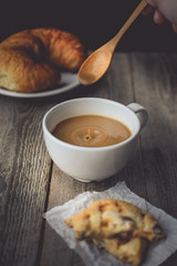 Motion of Drop falling to Hot Coffee with Cookies on Wood Backgr