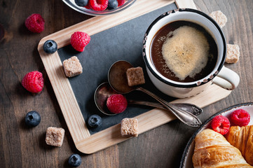 Coffee, croissants with raspberries and blueberries for breakfast, selective focus