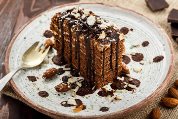 Tasty piece of chocolate Spartak cake on a rustic plate. Traditional delicious dessert on a table.