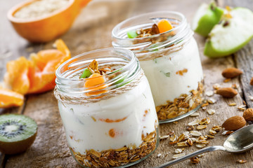 Granola with yogurt and fruits in a rustic jar. Delicious healthy American food for breakfast. Traditional US snack.