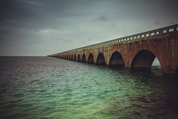 Colorful panoramic landscape of a beautiful  sunset at Bahia Honda state park in Florida and the old historic landmark, the Flagler railway bridge that used to connect Miami and Key West.