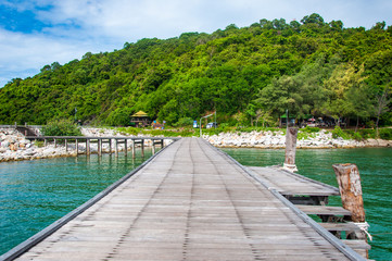 Beautiful Wooden Jetty  with Dramatic Sky and Green Island Backg