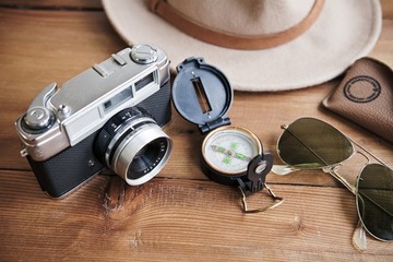 Planning next trip on table whith vintage camera, compass, sunglasses and hat.