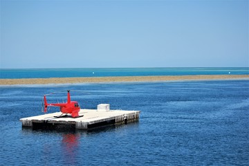 Red helicopter on a platform at sea