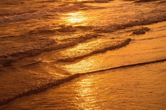Surface of water on the beach in the sunset time
