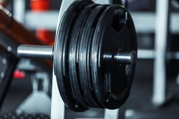 Obraz na płótnie Canvas Rack with weight plates in gym, close up view