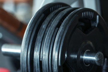 Fototapeta na wymiar Rack with weight plates in gym, close up view